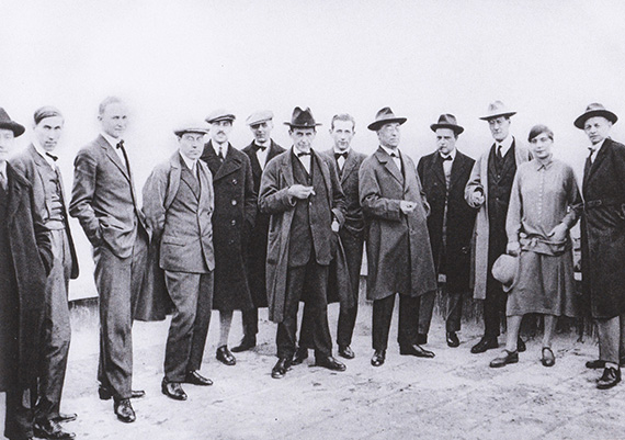 Abbildung zu: Die Bauhaus Meister auf dem Dach des Bauhausgel&auml;ndes in Dessau, Dez. 1926, von r. nach l.: Oskar Schlemmer, Gunta St&ouml;lzl, Lyonel Feininger, Paul Klee, Wassily Kandinsky, Marcel Breuer, Walter Gropius und weitere, Foto: unbekannt.
